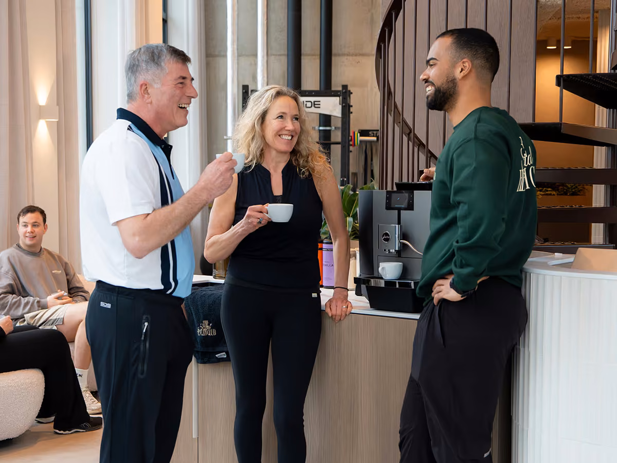 Leden drinken samen koffie aan de bar van de club